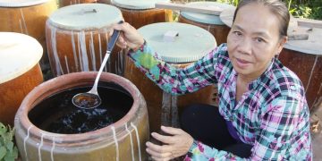 Bay Muon with her urns of fish sauce in Can Tho City, Vietnam. Photo: Chi Cong / Tuoi Tre